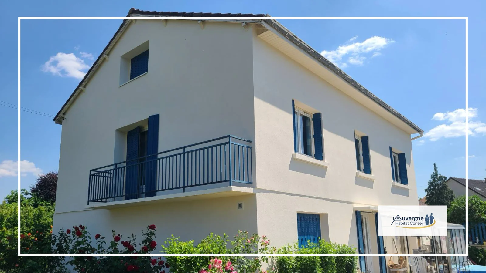 Façade de maison rénovée avec enduit clair et volets bleus