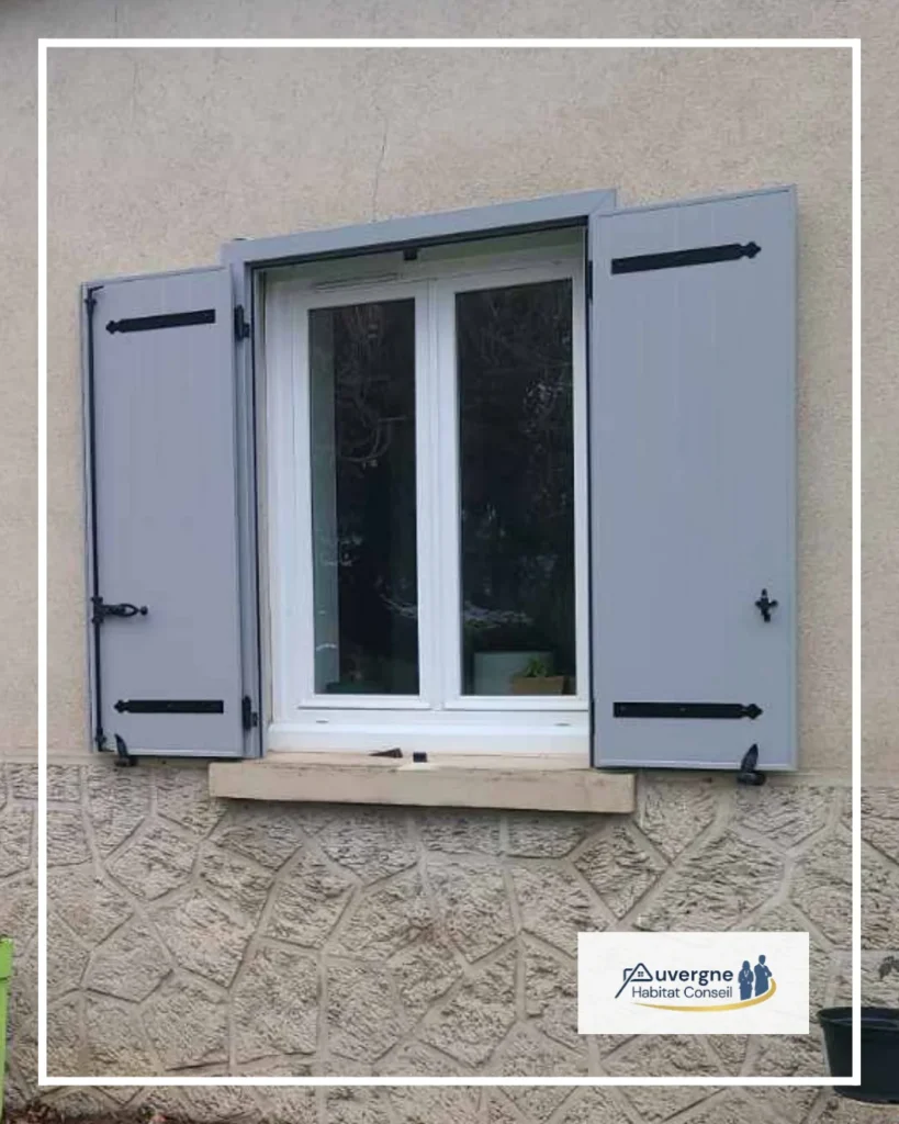 Volets battants gris sur une fenêtre blanche